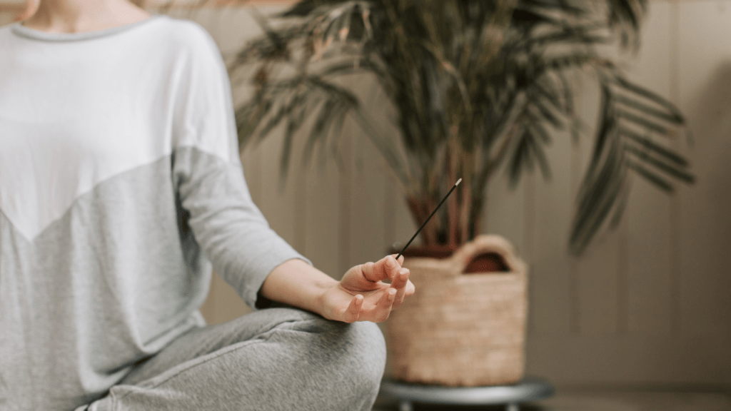 A person meditating in a yoga pose on a mat