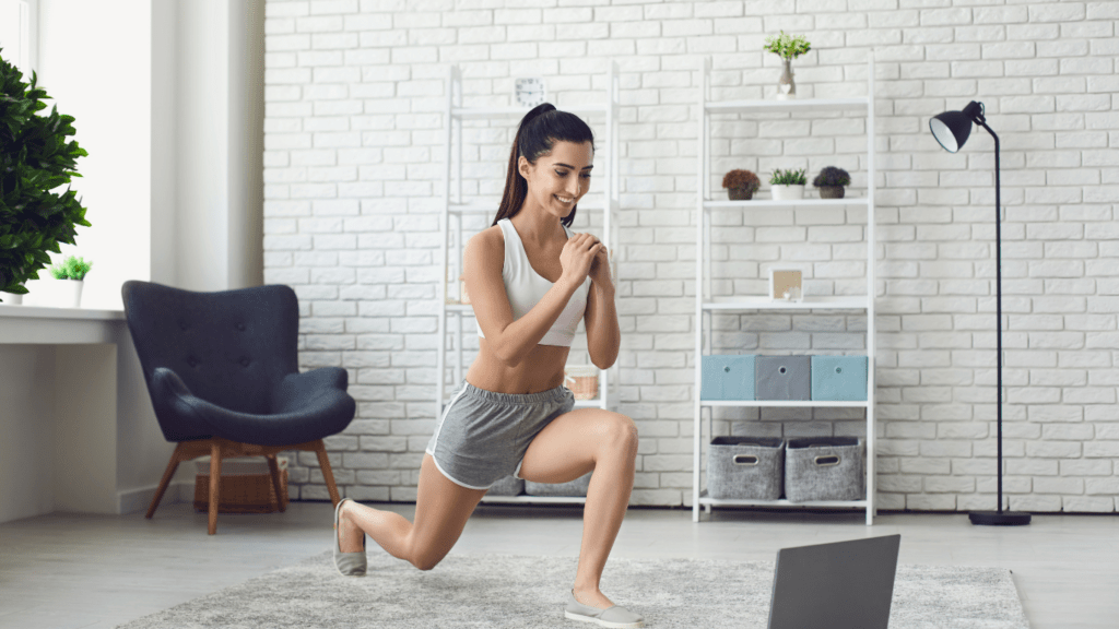 a person is doing squats in front of a laptop