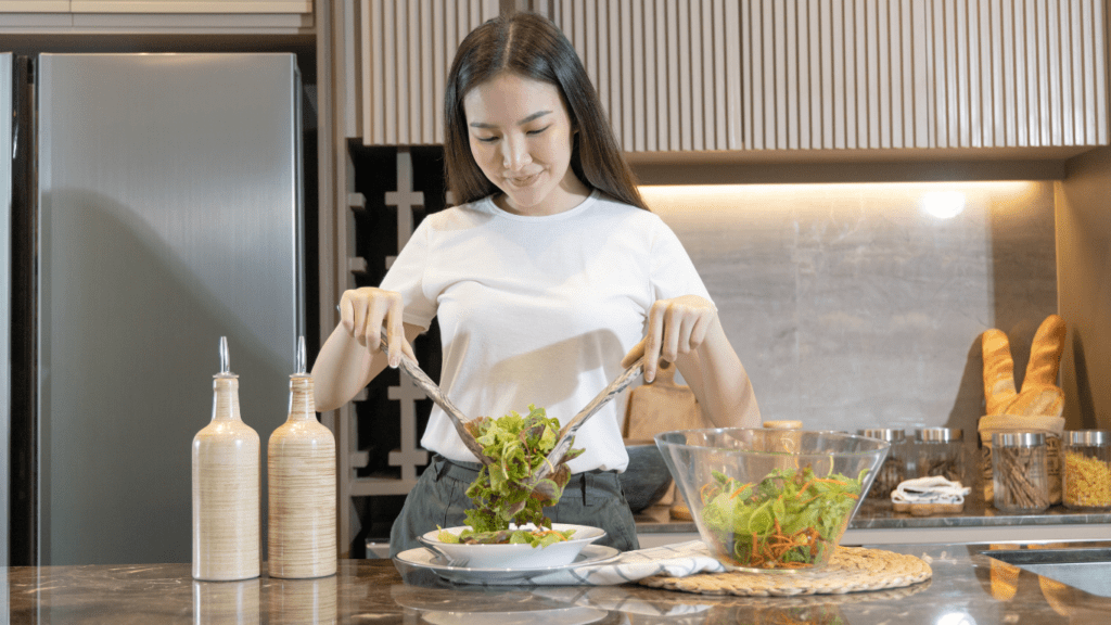 A person preparing salad in the kitchen