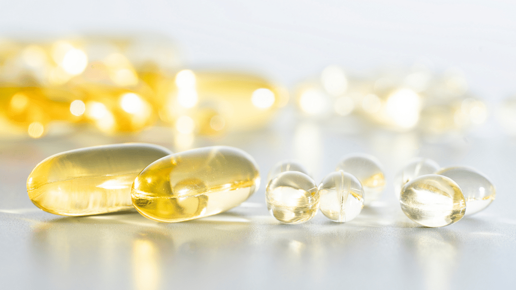 a bowl full of fish oil capsules on a white surface