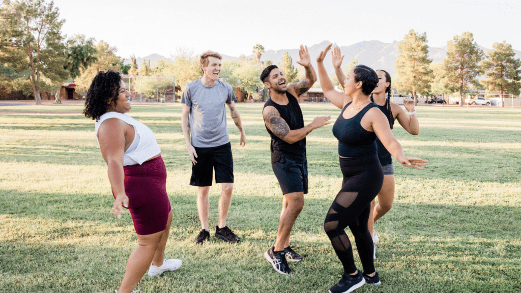 a group of people playing frisbee in a park