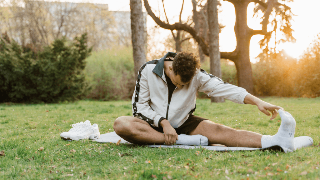 a person stretching on the grass in the park