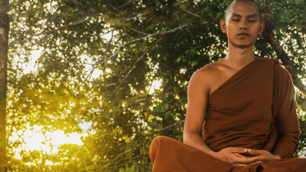 a buddhist monk meditating in the forest