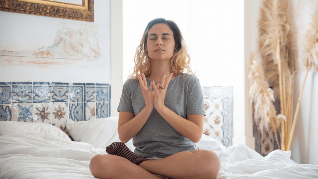 Someone meditating on a bed