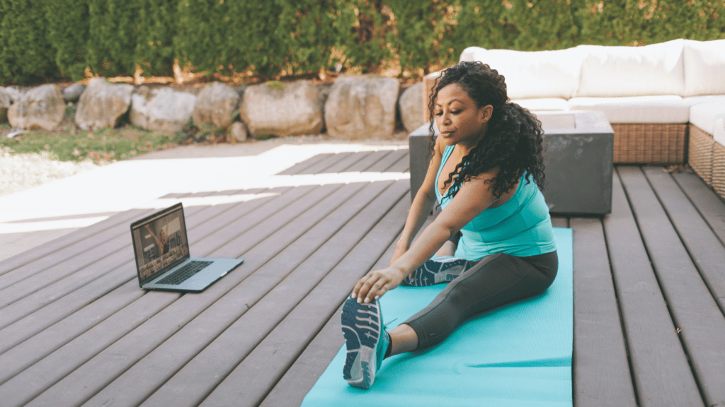 Someone is doing yoga in front of a laptop