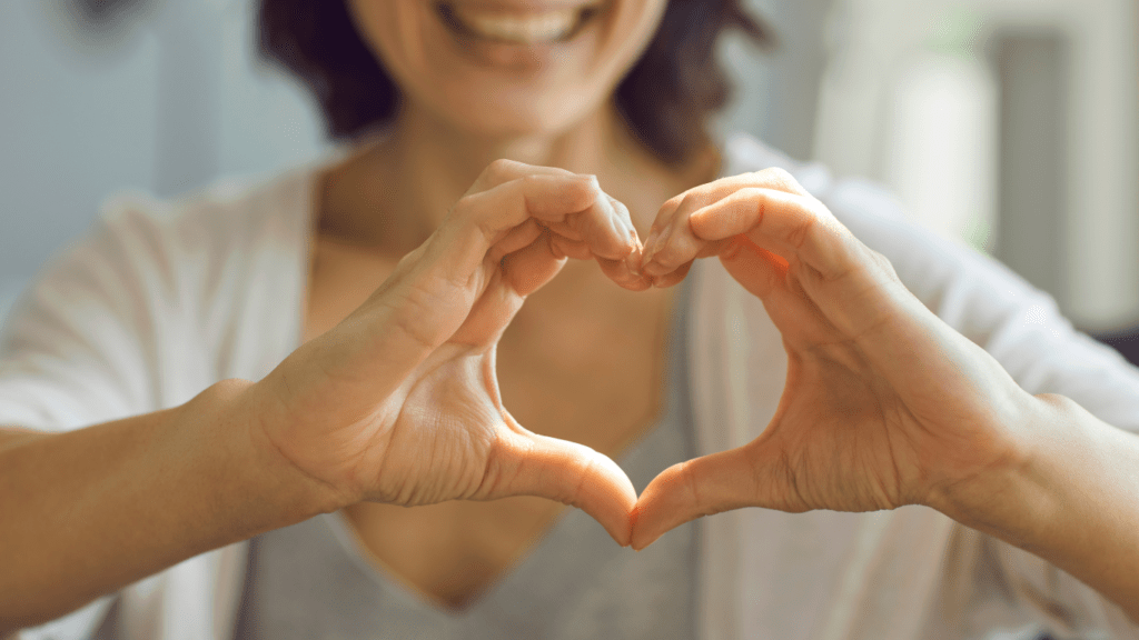 a person making a heart shape with their hands