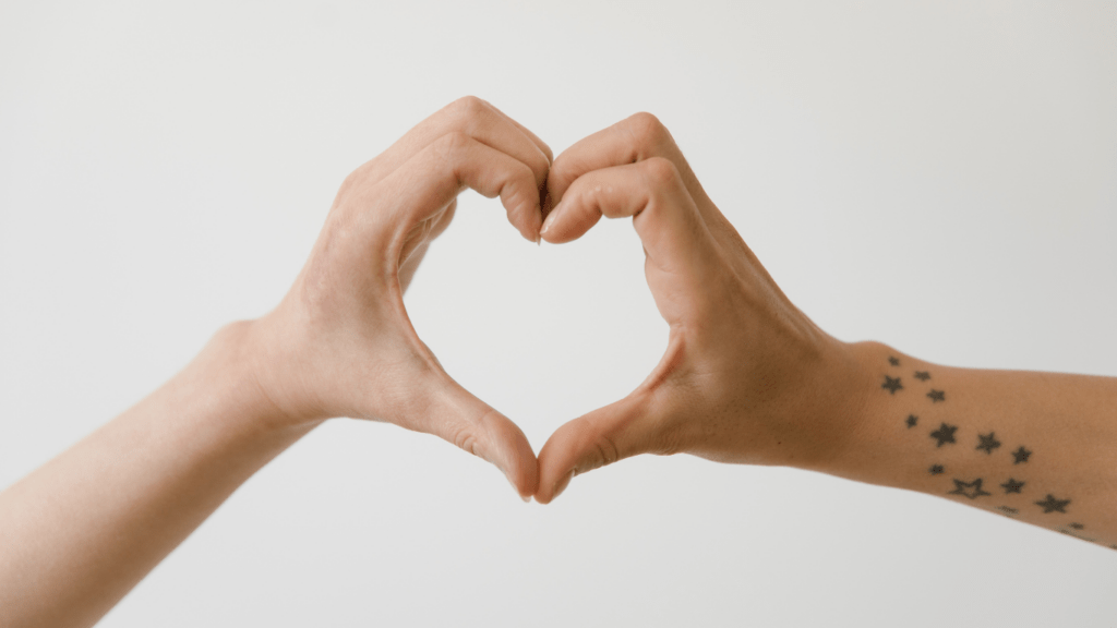 a person making a heart shape with their hands