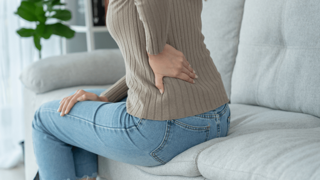 a person sitting on a couch with back pain