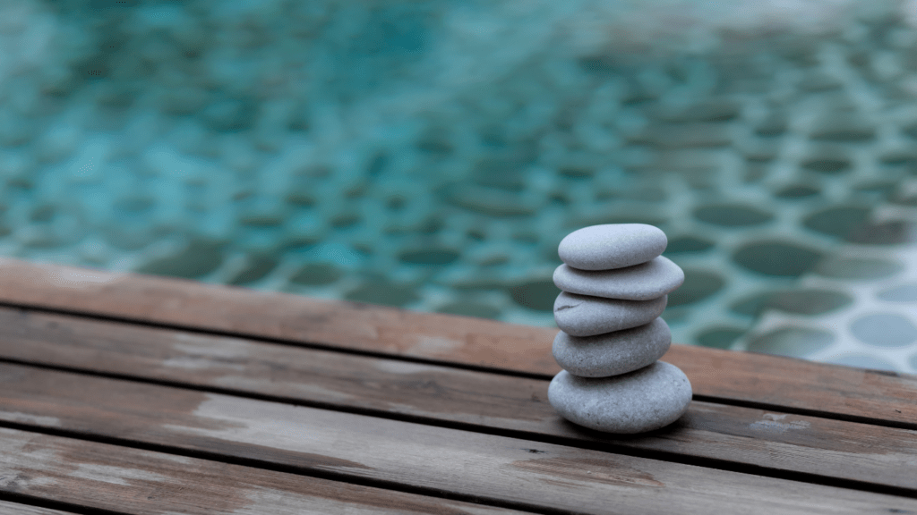 a stack of stones is sitting on top of a rock by the ocean