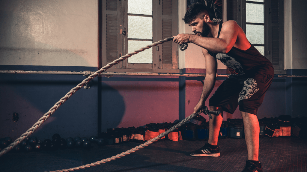 people are doing battle ropes in a gym.